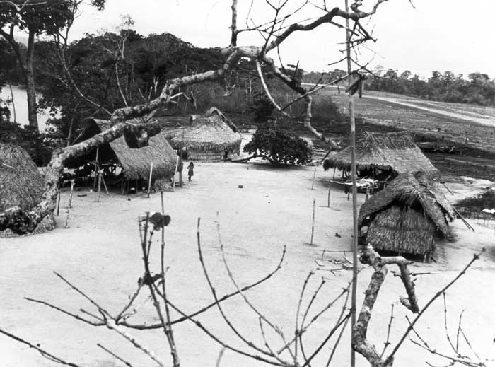 Vista parcial da aldeia Bona Vista parcial da aldeia Bona (antigo nome da aldeia Apalai): pátio central e casas de tipo semi-tradicional. Ao fundo, a pista de pouso da FAB. Foto: Daniel Schoepf, 1972.