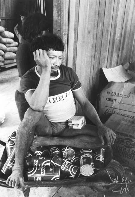 Kãyipayerä sentado em cima de latas de óleo na casa do chefe do Posto Indígena Ipixuna. Foto: Eduardo Viveiros de Castro, 1982.