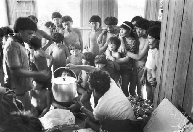 Chefe do Posto Indígena Ipixuna (Eliezer G. da Silva) distribuindo bens encomendados pelos índios, comprados em Altamira com o dinheiro resultante da venda à FUNAI de seu artesanato. Foto: Eduardo Viveiros de Castro, 1982.