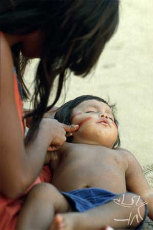 Mãe pintando criança com urucum. Aldeia Córrego Grande, MT Foto: Waldir de Pina, 1985