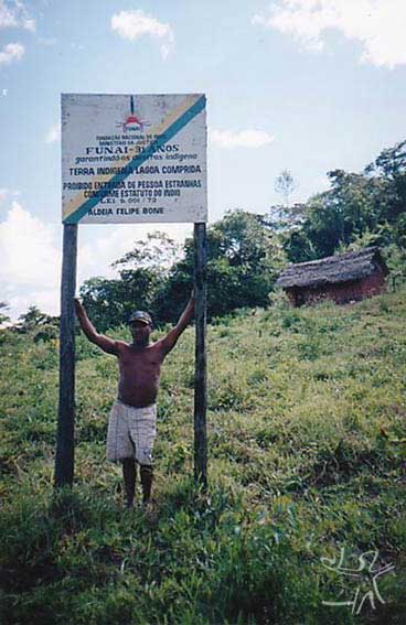 Capitão Felipe Bone com placa da aldeia com seu nome (TI Lagoa Comprida). Foto: Peter Schröder, 2000