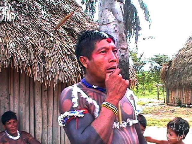 Homem tocando a flauta dos mortos no fim de uma cauinagem. Foto: Tânia Stolze Lima. Aldeia de Tubatuba, 2001.