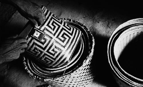 Índio baniwa do alto Içana (Amazonas) coloca etiqueta com a logomarca “arte baniwa” num urutu de arumã, cestaria que é comercializada em São Paulo. Foto: Pedro Martinelli, 2000.