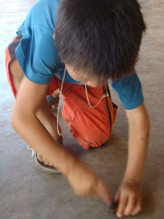 Kadu roda seu peão feito com semente de tucum. Aldeia Tuba Tuba. Foto: Paula Mendonça/ISA, 2009.