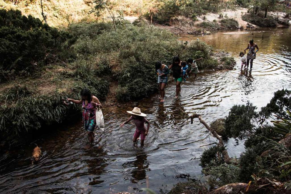 Mulheres e crianças se refrescam no rio após mutirão de plantio, na aldeia retomada Yrexakã, São Paulo, SP, Brasil. Foto: Luiza Mandetta Calagian, 2015.