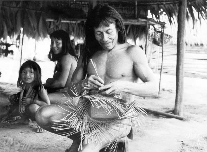 O aparai Mikita fazendo uma cesta em aldeia no Rio Paru de Leste; ao fundo, sua esposa wayana. Foto: Daniel Schoepf, 1976.